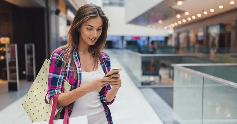 Woman looking at her phone in a shopping center