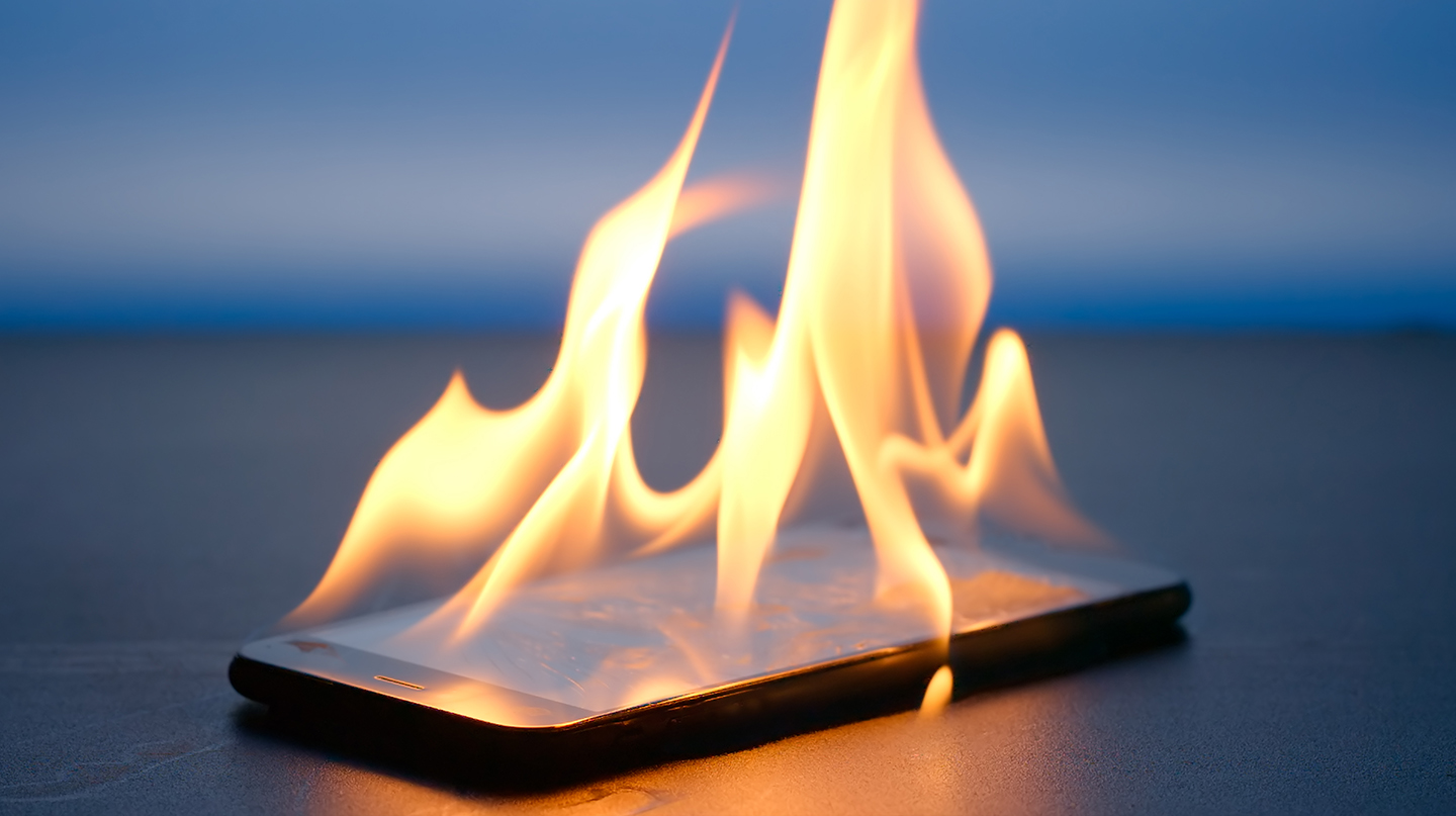 cell phone on fire representing a burner cell phone