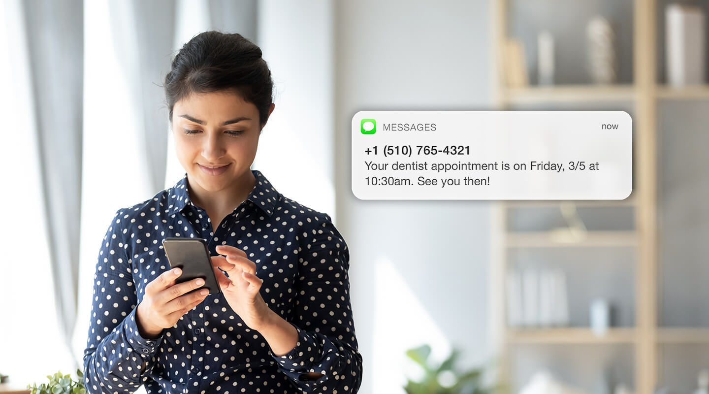 A woman looking at an SMS appointment confirmation.